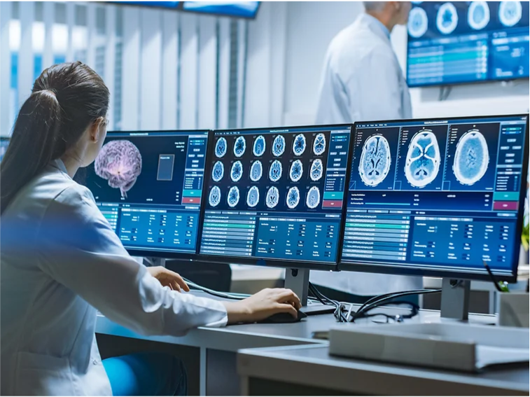 Medical worker looking at brain scans on multiple screens